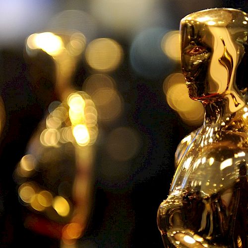 The image shows several golden statuettes in the shape of a human figure. These are commonly known as Oscars, awarded in the film industry worldwide.